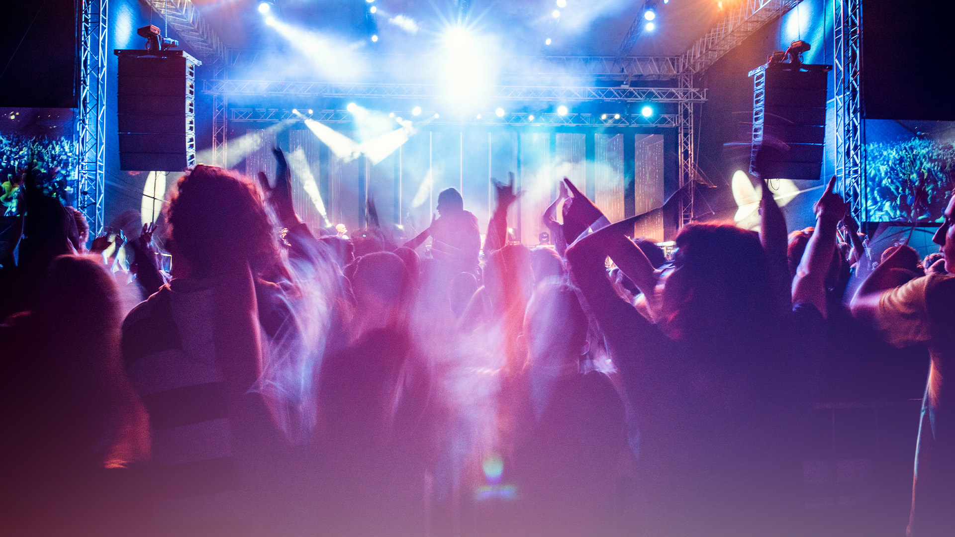 People dancing at a club to a DJ spinning records