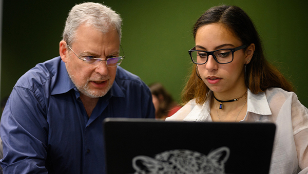 A faculty member helps a student.